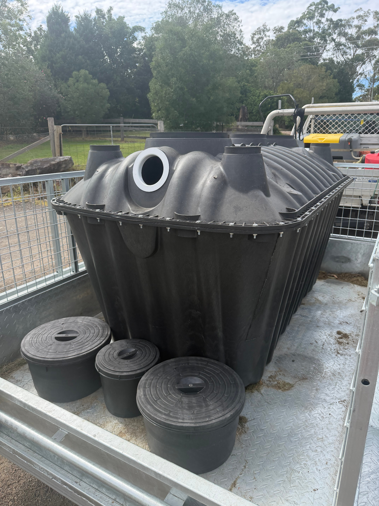 Bush Billabongs 1500L septic tank loaded on a ute trailer with three inspection lids ready for delivery